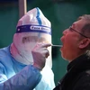 Nhân viên y tế lấy mẫu xét nghiệm COVID-19 cho người dân tại Thiên Tân, Trung Quốc, ngày 15/1/2022. (Ảnh: THX/TTXVN)