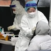 Nhân viên y tế lấy mẫu xét nghiệm COVID-19 cho một em nhỏ tại Seoul, Hàn Quốc ngày 16/2. (Ảnh: THX/TTXVN)