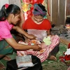 Cô đỡ thôn bản huyện Minh Hóa (Quảng Bình) chăm sóc sức khoẻ sinh sản cho đồng bào dân tộc. (Ảnh: Dương Ngọc/TTXVN) 