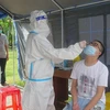 Nhân viên tại Trạm y tế lưu động xét nghiệm SARS-CoV-2 cho người dân. (Ảnh: TTXVN) 