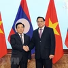 Thủ tướng Phạm Minh Chính bắt tay Thủ tướng Lào Phankham Viphavanh. (Ảnh: Dương Giang/TTXVN)