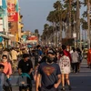 Người dân đi dạo trên bãi biển ở Mỹ. (Ảnh: AFP/TTXVN)