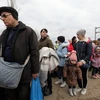 Người dân Ukraine sơ tán tránh xung đột tới cửa khẩu ở Palanca, khu vực biên giới giữa Moldova và Ukraine. (Ảnh: AFP/TTXVN)