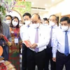 Chủ tịch nước Nguyễn Xuân Phúc thăm khu trưng bày các sản phẩm tiêu biểu của huyện Hóc Môn và Củ Chi. (Ảnh: Thống Nhất/TTXVN) 
