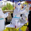 Nhân viên y tế lấy mẫu xét nghiệm COVID-19 cho người dân tại Thượng Hải, Trung Quốc, ngày 6/4/2022. (Ảnh: THX/TTXVN)