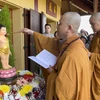 Thượng Tọa Thích Tâm Huy, Trụ trì Trúc Lâm Thiền viện thực hiện nghi lễ tắm Phật. (Ảnh: Thu Hà/TTXVN)