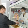 Khử khuẩn tay, đo thân nhiệt, nhằm ngăn chặn sự lây lan của dịch COVID-19 trước khi vào trung tâm thương mại ở Bình Nhưỡng, Triều Tiên. (Nguồn: AFP/TTXVN)