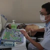 Bác sỹ trên tàu bệnh viện Khánh Hòa 01 siêu âm cho bệnh nhân. (Ảnh: Xuân Triệu/TTXVN) 