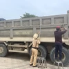 Lực lượng cảnh sát giao thông tiến hành cưỡng chế tháo, cắt thùng xe vi phạm. (Ảnh: Nguyễn Thanh/TTXVN)