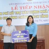 Ông Đinh Đăng Quang, Ủy viên Ban chấp hành Công đoàn Viên chức Việt Nam, Phó Tổng Giám đốc, Chủ tịch Công đoàn TTXVN trao hỗ trợ cho tỉnh Quảng Trị. (Nguồn: TTXVN) 