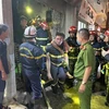 Lực lượng Cảnh sát phòng cháy chữa cháy và cứu nạn cứu hộ đưa người bị nạn ra khỏi đám cháy. (Ảnh TTXVN phát)