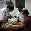 Tổ quân y cứu chữa cho ngư dân Trần Ngọc Toàn (sinh năm 1985, quê quán ở Vạn Giã, Vạn Ninh, Khánh Hòa) bị dập nát đốt 1 ngón tay út của bàn tay phải. (Ảnh: TTXVN phát)