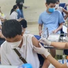 Nhân viên y tế phường Minh Khai tiêm mũi vaccine nhắc lại cho học sinh trường THCS Hà Huy Tập. (Ảnh: Tuấn Đức/TTXVN)