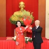 Chủ tịch Hội Chữ thập Đỏ Việt Nam Bùi Thị Hòa tặng hoa chúc mừng Tổng Bí thư Nguyễn Phú Trọng. (Ảnh: Trí Dũng/TTXVN) 