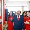 Chủ tịch nước Nguyễn Xuân Phúc tham quan khu trưng bày hoạt động của Hội Chữ thập Đỏ Việt Nam qua các thời kỳ. (Ảnh: Thống Nhất/TTXVN)