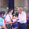 Nguyên Phó Thủ tướng Thường trực Chính phủ Trương Hòa Bình trao tăng quà, bánh trung thu cho các em thiếu nhi tại chương trình Trung thu yêu thương năm 2022 vào 11/9. (Ảnh: Thanh Vũ/TTXVN)