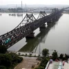 Xe tải chở hàng hóa đi qua cầu Hữu nghị (trái) từ Đan Đông, Trung Quốc, đến thành phố Sinuiju, Triều Tiên. Ảnh minh họa. (Nguồn: Reuters) 