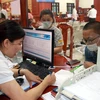 Giải quyết các thủ tục hành chính tại Trung tâm phục vụ hành chính công, xúc tiến đầu tư và hỗ trợ doanh nghiệp tỉnh Nam Định. (Ảnh: Văn Đạt/TTXVN) 