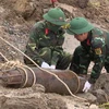 Ban chỉ huy quân sự thành phố Việt Trì, tỉnh Phú Thọ, phối hợp với các lực lượng liên quan tiến hành di dời quả bom. (Ảnh: Trung Kiên/TTXVN)