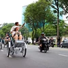 Du khách quốc tế tham quan trung tâm Thành phố Hồ Chí Minh bằng xích lô. (Ảnh: Hồng Đạt/TTXVN) 