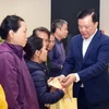 Bí thư Thành ủy Hà Nội Đinh Tiến Dũng tặng quà Tết cho các hộ gia đình có hoàn cảnh khó khăn trên địa bàn huyện Gia Lâm. (Ảnh: Văn Điệp/TTXVN)