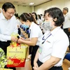 Trưởng Ban Nội chính Trung ương Phan Đình Trạc thăm hỏi, chúc Tết, tặng quà cho công nhân tại Bình Dương. (Ảnh: TTXVN phát)
