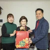 Đại biện lâm thời Nguyễn Việt Anh (phải) tặng quà Tết cho gia đình chị Nga. (Ảnh: Anh Nguyên/TTXVN)
