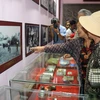Đại biểu xem trưng bày hình ảnh, hiện vật tại nhà lưu niệm trong Khu di tích căn cứ Tỉnh ủy Bình Thuận trong kháng chiến chống Mỹ. (Ảnh: Nguyễn Thanh/TTXVN)