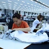 Công nhân sản xuất hàng may mặc tại Công ty trách nhiệm hữu hạn Kydo Việt Nam. (Ảnh: Phạm Kiên/TTXVN) 
