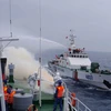 Lực lượng trên tàu tuần tra Settsu và lực lượng trên tàu của Vùng Cảnh sát biển 2 thực hành chống cháy nổ trên biển. (Ảnh: Đoàn Hữu Trung/TTXVN) 