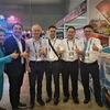 Trưởng đại diện Vietnam Airlines tại Malaysia Hoàng Minh Trí (thứ ba, từ phải sang) chụp ảnh kỷ niệm cùng các đối tác tại quầy hàng. (Ảnh: Hằng Linh/TTXVN)