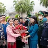 Lãnh đạo thành phố Móng Cái tặng hoa chúc mừng các đoàn khách quốc tế đầu tiên qua cửa khẩu quốc tế Móng Cái. (Ảnh: TTXVN phát)