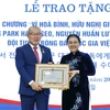 Chủ tịch Liên hiệp các tổ chức hữu nghị Việt Nam Nguyễn Phương Nga trao Kỷ niệm chương cho ông Park Hang Seo. (Ảnh: An Đăng/TTXVN)