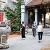 Du khách nước ngoài tham quan đình Kim Ngân trong khu phố cổ Hà Nội. (Ảnh: Thanh Tùng/TTXVN)