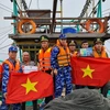 Cảnh sát biển Việt Nam tặng cờ Tổ quốc cho ngư dân trên biển. (Ảnh: TTXVN phát)