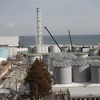 Lò phản ứng số 4 (trái) và các bể chứa nước nhiễm xạ tại nhà máy điện hạt nhân Fukushima Daiichi ở tỉnh Fukushima, Nhật Bản. (Nguồn: AFP/TTXVN) 