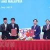 Thủ tướng Phạm Minh Chính và Thủ tướng Anwar Ibrahim chứng kiến lễ ký Bản ghi nhớ về hợp tác giữa Liên đoàn Thương mại và Công nghiệp Việt Nam với Phòng Thương mại và Công nghiệp Quốc gia Malaysia ngày 20/7/2023. (Ảnh: Dương Giang/TTXVN) 