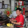 Ông Nguyễn Văn Quởn làm việc tại cửa hàng của mình. (Ảnh: Minh Trí/TTXVN)