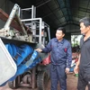 Anh Phùng Văn Nam (bên trái) giới thiệu sản phẩm máy cày phay lên luống đến với người dân. (Ảnh: Thanh Thương/TTXVN)