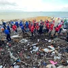 Lực lượng tình nguyện thu gom rác tại bãi biển Vũng Tàu. (Ảnh: TTXVN phát) 