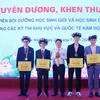 Em Nguyễn Tuấn Phong (ngoài cùng, bên trái) được tuyên dương học sinh đoạt giải quốc tế. (Ảnh: Thái Hùng/TTXVN) 