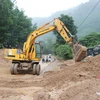Công ty Cổ phần Xây dựng Giao thông Quảng Ngãi thu dọn đất đá bị sạt lở, khơi thông trên tuyến DT.626 huyện Sơn Hà, tỉnh Quảng Ngãi, (Ảnh: Phạm Cường/TTXVN) 