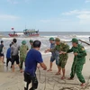 Bộ đội Biên phòng tỉnh Quảng Trị hỗ trợ ngư dân cố định tàu cá mắc cạn. (Ảnh: TTXVN phát) 