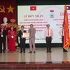 Ông Latanaphayvanh Dai, Bí thư thứ nhất nước Cộng hòa Dân chủ Nhân dân Lào tại Việt Nam, trao Huân chương Hữu nghị cho Trường Cao đẳng Thái Nguyên. (Ảnh: Quân Trang/TTXVN)