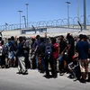 Người di cư chờ xét duyệt bên ngoài Cơ quan Kiểm soát Biên phòng Mỹ, sau khi vượt qua biên giới Mexico vào El Paso, bang Texas (Mỹ), ngày 9/5/2023. (Nguồn: AFP/TTXVN)