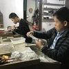 Nghệ nhân Phạm Bình Minh kiểm tra chất lượng dây truyền bạc. (Ảnh: Tiến Vĩnh/TTXVN)