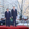 Thủ tướng Phạm Minh Chính và Thủ tướng Romania Ion-Marcel Ciolacu nghe quân nhạc cử Quốc thiều hai nước. (Ảnh: Dương Giang/TTXVN)