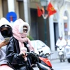 Nhiều người mặc kín mít khi đi xe máy ngoài đường trong thời tiết lạnh giá. (Ảnh: Tuấn Anh/TTXVN)