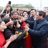 Thủ tướng Phạm Minh Chính với công nhân, người lao động tại "Ngày hội công nhân - Đón chào Xuân mới" 2024. (Ảnh: Dương Giang/TTXVN)