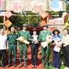 Hai anh em Nguyễn Tiến Thành và Nguyễn Tiến Đạt chụp ảnh lưu niệm cùng lãnh đạo huyện Phú Riềng và Ban Chỉ huy Quân sự huyện. (Ảnh: TTXVN phát)